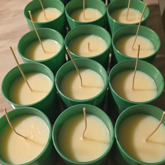 Green containers with small candles on a wooden surface