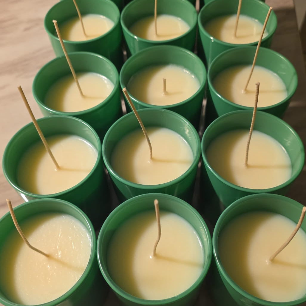 Green containers with small candles on a wooden surface